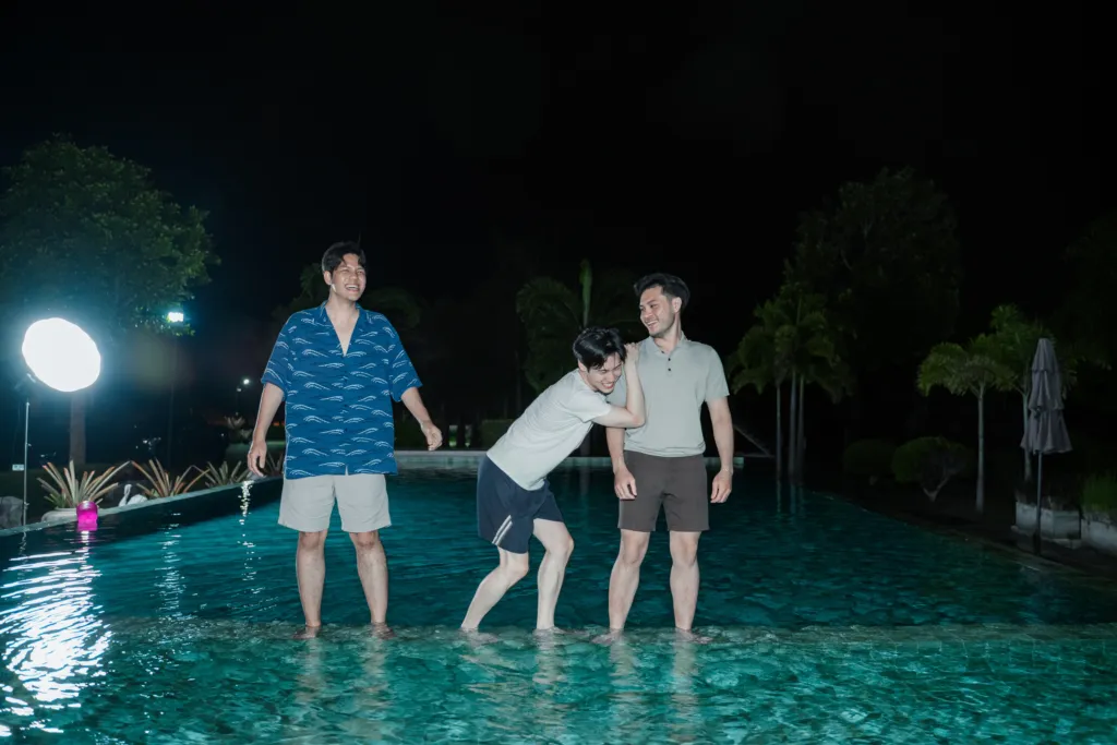 Friends enjoying night-time poolside fun.