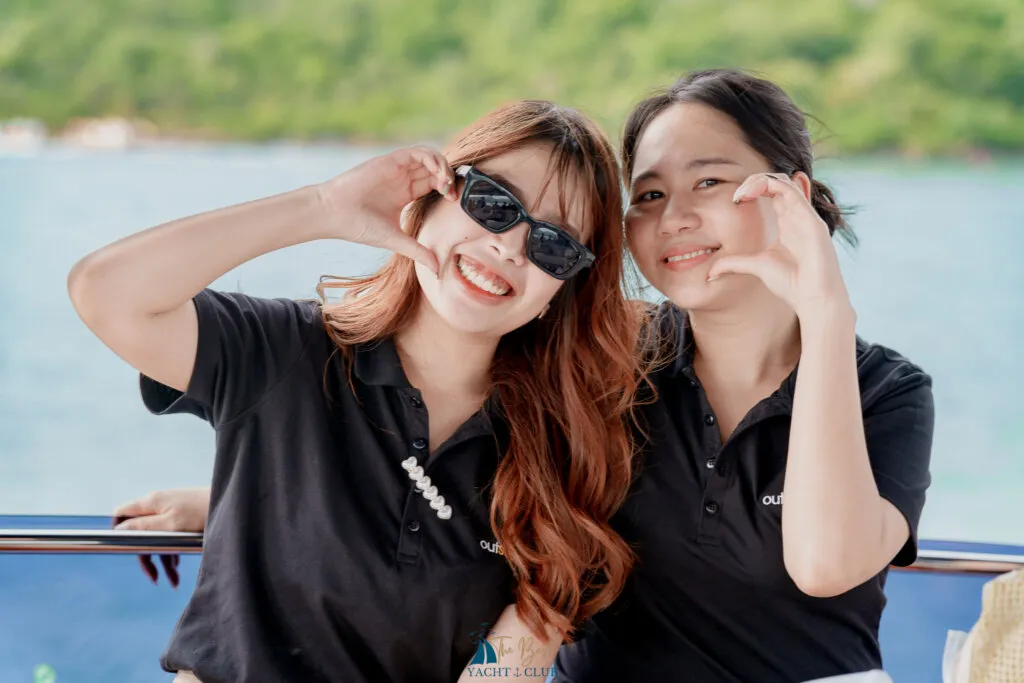 Two women smiling on a boat deck.