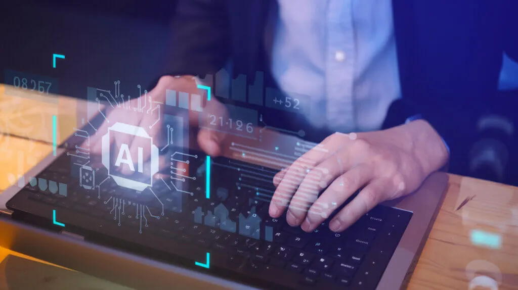 Person typing on laptop with AI hologram.