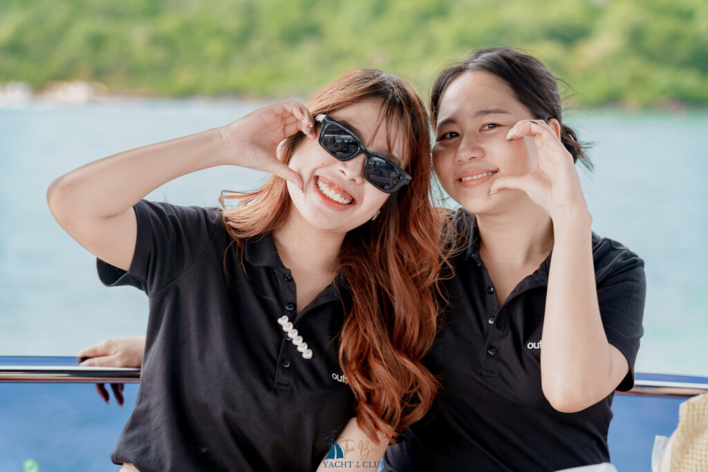 Two women smiling on a boat deck.