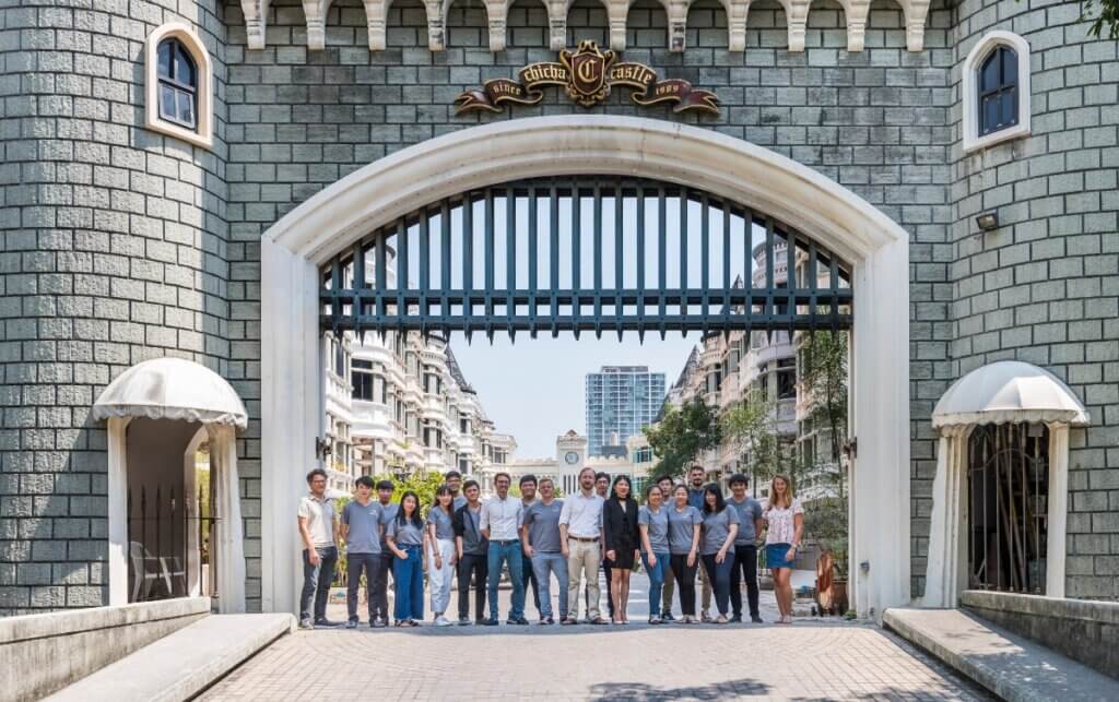 Group standing under castle-style archway.